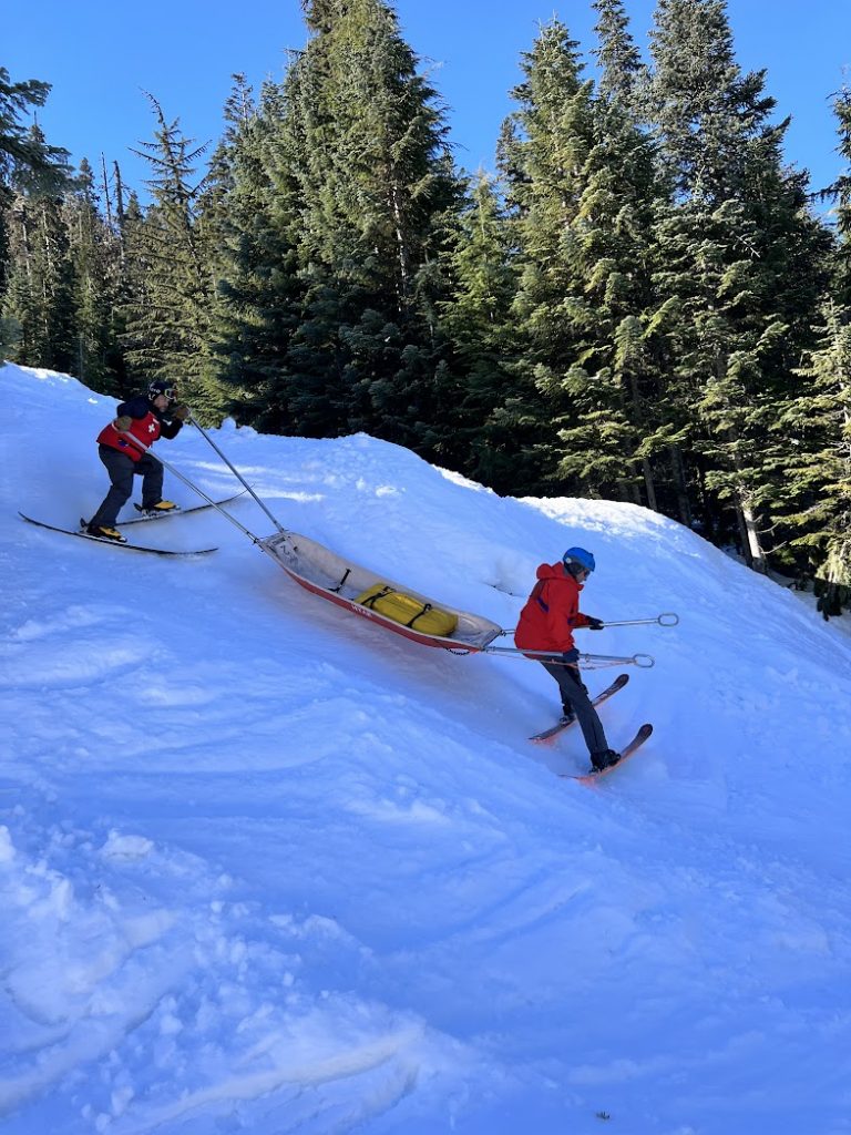 Ski Patrollers practicing sled handling skills in steep terrain.